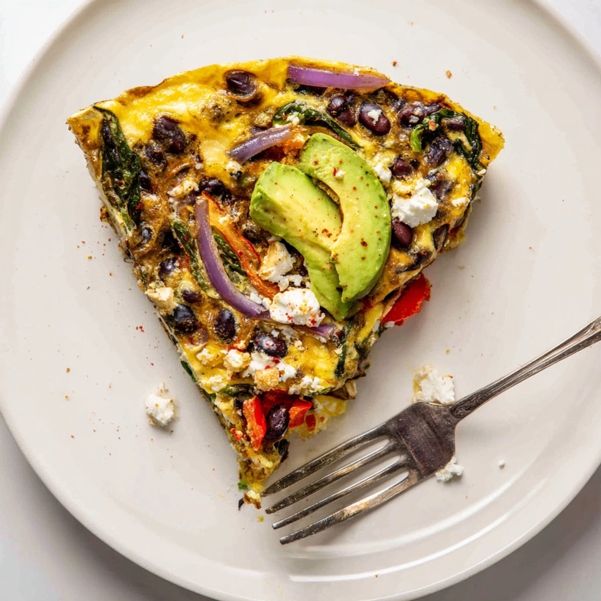 Golden baked Avocado Black Bean Egg Frittata, bubbling hot in a skillet, ready to serve.