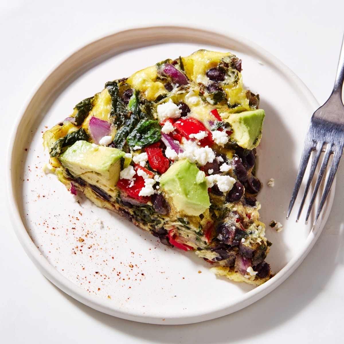 Freshly baked Avocado Black Bean Egg Frittata with a sprinkle of feta, visually appealing brunch.