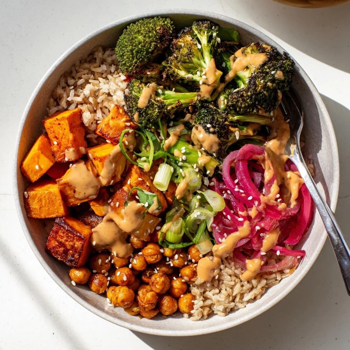 Colorful grain bowls featuring gochujang-maple drizzle, roasted sweet potatoes, and chickpeas.  
