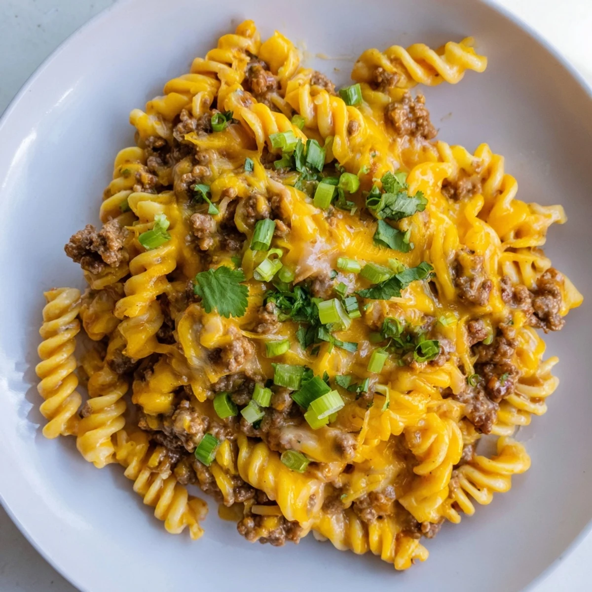 Steaming hot Cheesy Taco Pasta Skillet topped with melted cheese, ready for serving tonight.