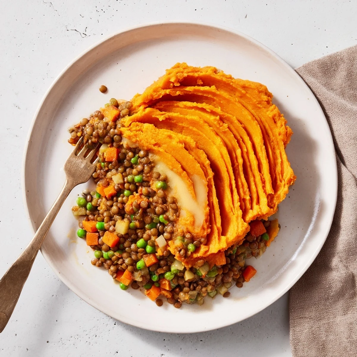 Steaming hot Veggie Shepherd's Pie overflowing in a baking dish, topped with sweet potato mash.