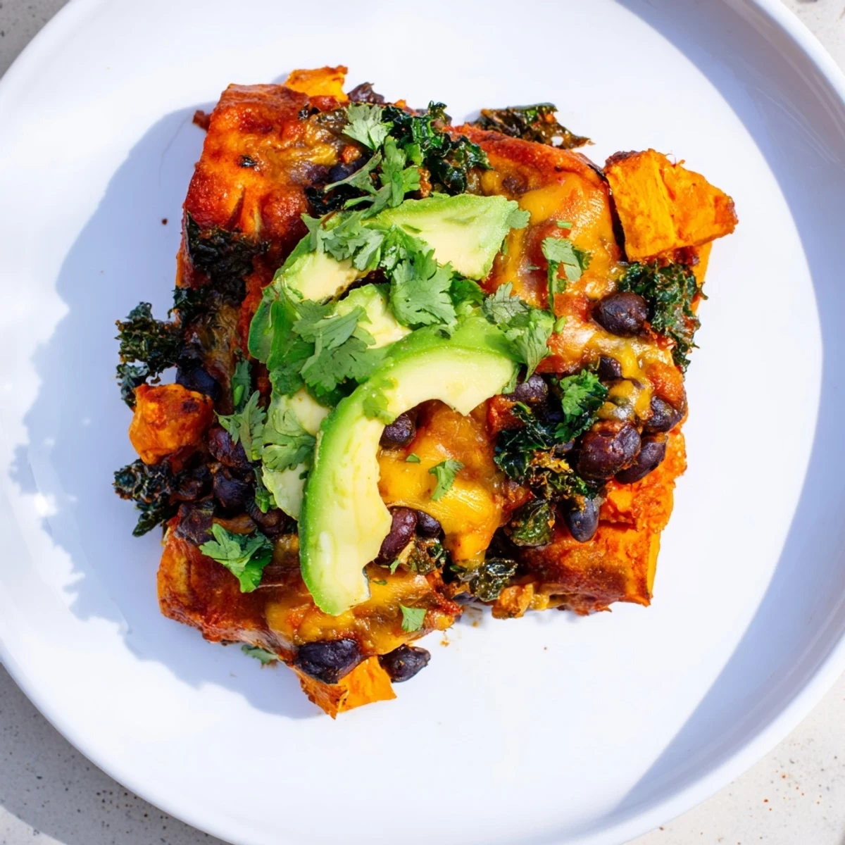 Golden-brown, bubbly One-Pan Sweet Potato, Black Bean & Kale Enchiladas, a vegetarian delight, perfectly baked.