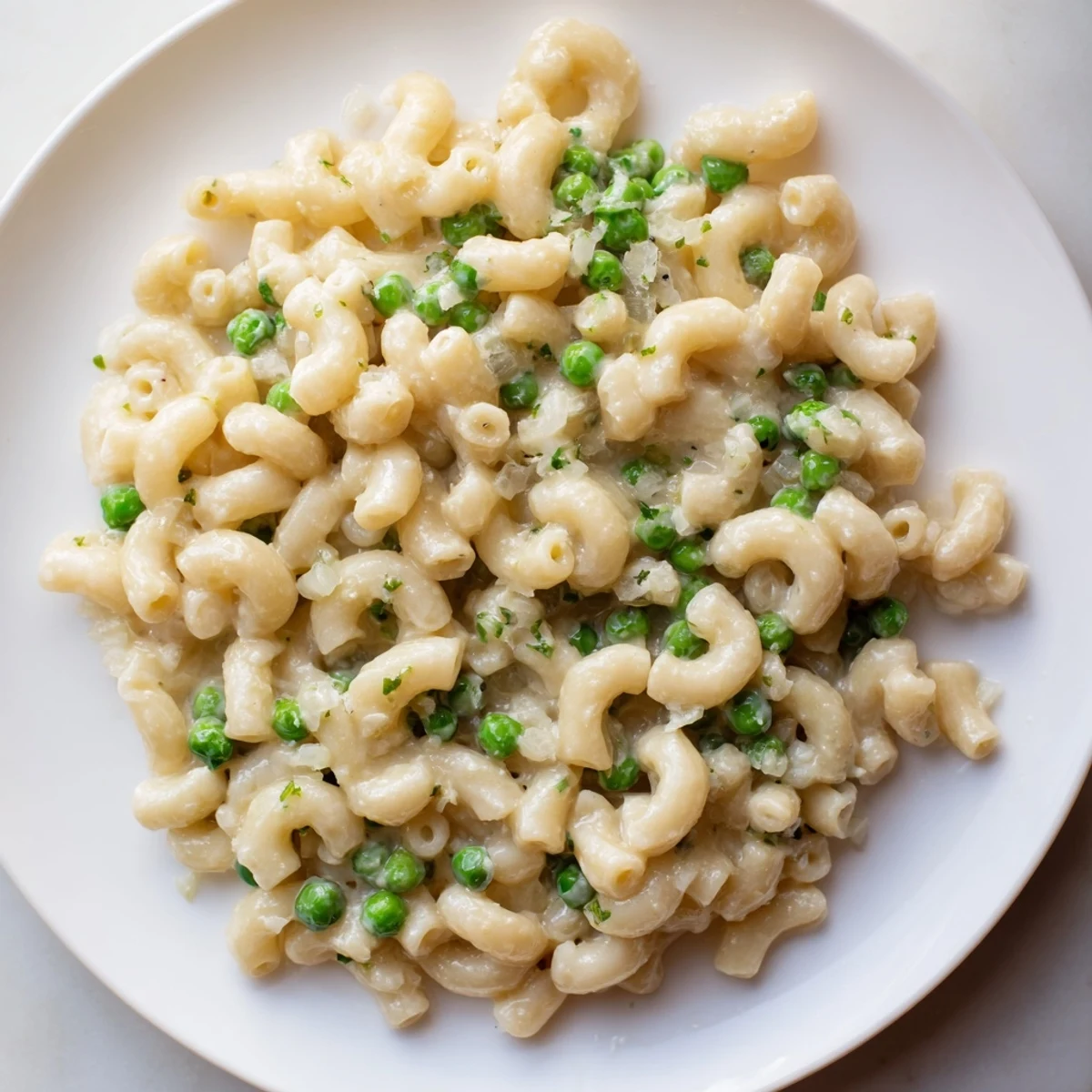 Steaming bowl of Macaroni & Peas, creamy and cheesy, ready to be enjoyed as a family meal.