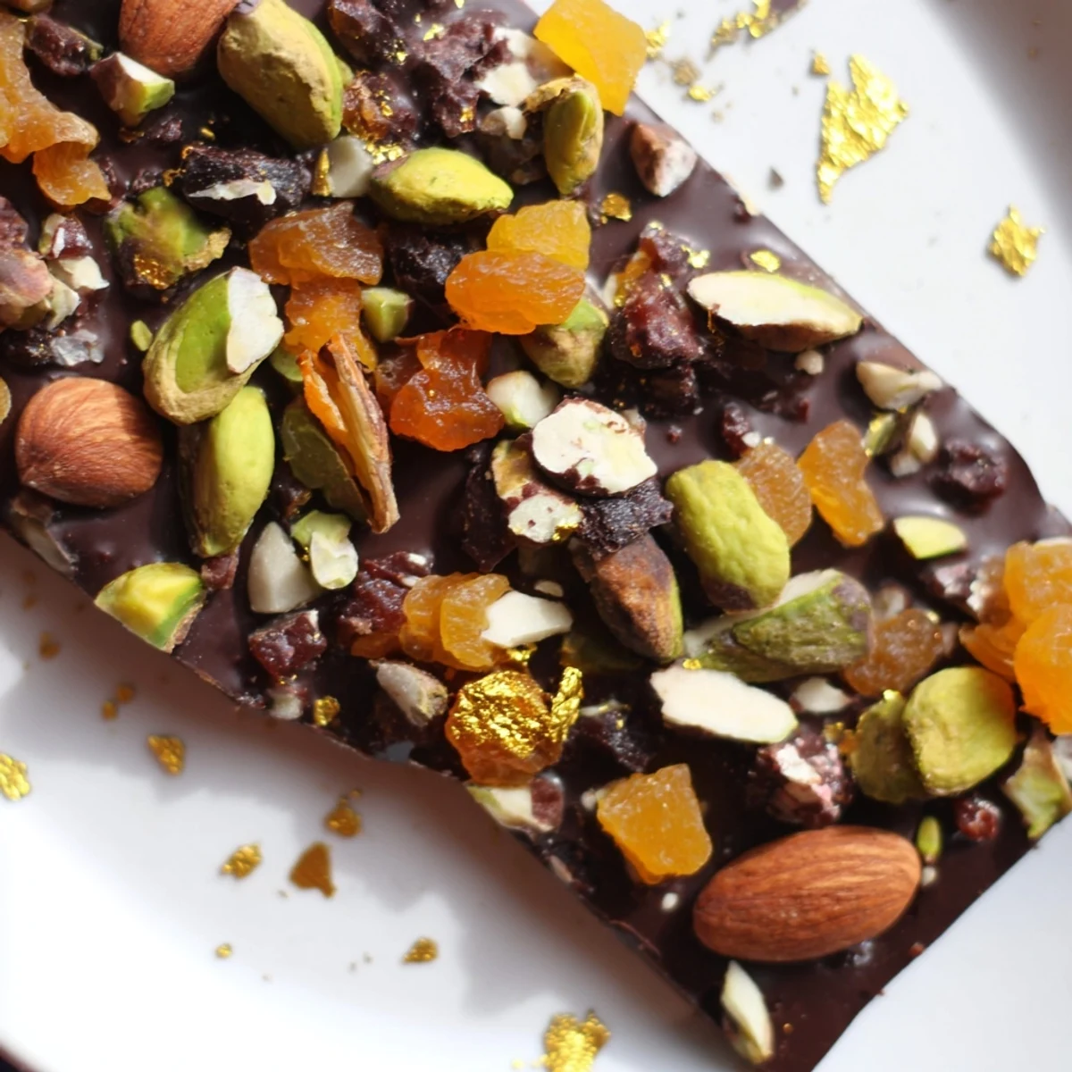 A flat layer of rich, dark Simplified Dubai Chocolate Bark, scattered with colorful dried fruits and nuts.