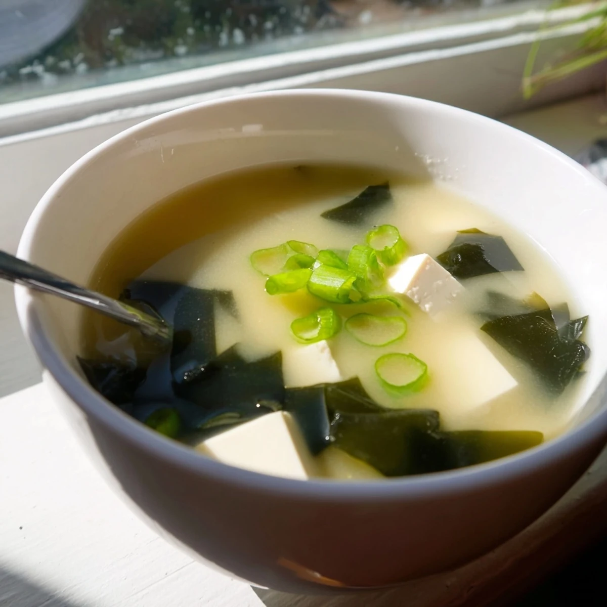 Silky cubes of tofu and tender wakame seaweed float in warm, savory broth for this classic Miso Soup With Tofu.