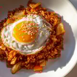 Vibrant kimchi fried rice with carrots and onions sizzling in a wok, ready to eat.