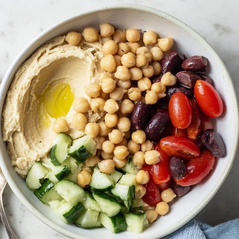 Fresh Mediterranean Chickpea Bowl garnished with colorful veggies and creamy hummus.  