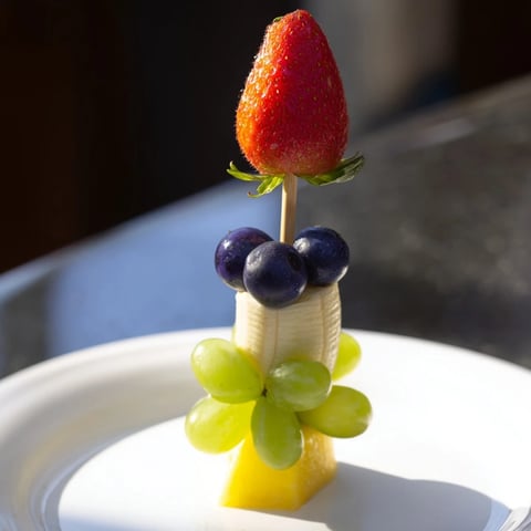 Bright, colorful Rocket Ship Fruit Skewers feature strawberries, grapes, and pineapple ready to eat.