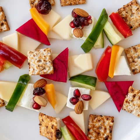 A stunning Tessellation Triangle appetizer, showcasing colorful cheese, fruit, and veggie triangles artfully arranged.