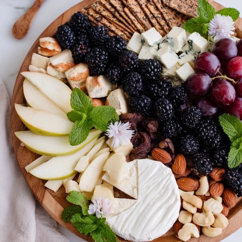 The Yin-Yang Balance appetizer board features blackberries dividing cheeses, fruits, and crackers for sharing.
