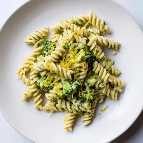 A vibrant bowl of Green Goddess Broccoli Cheddar One-Pot Pasta with melty cheese and fresh herbs.