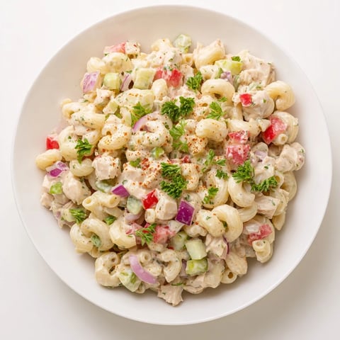 Chicken Macaroni Holiday Salad glistening on a plate, featuring tender macaroni and colorful vegetables.