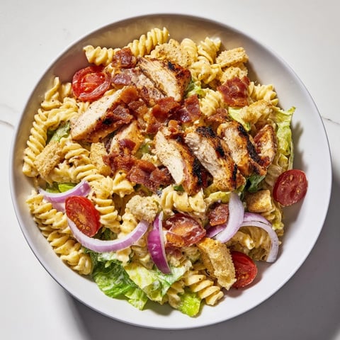 Chicken Caesar Pasta Salad, a creamy delight, showcases rotini, grilled chicken, bacon, and fresh vegetables.