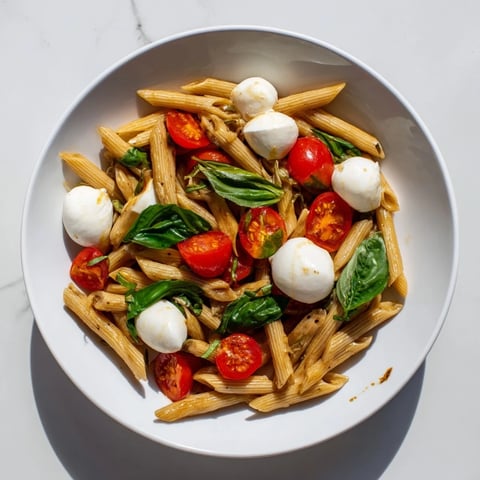 Caprese Pasta Salad, a colorful mix with juicy tomatoes and creamy mozzarella, perfect for summer.