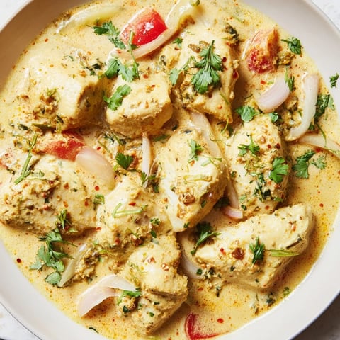 Vibrant Bahraini Fish Curry served with fluffy rice, showcasing tender fish in rich, spiced coconut sauce.