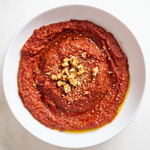 Creamy, vibrant Syrian Muhammara dip, perfect for dipping with warm pita bread and vegetable sticks.