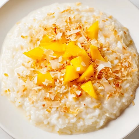 Creamy Coconut Rice Sweet, garnished with tropical fruit and toasted coconut flakes, ready to enjoy.