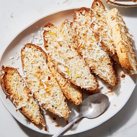 Close-up of crisp Ricotta Lemon Coconut Biscotti showing coconut flakes and hints of lemon zest.