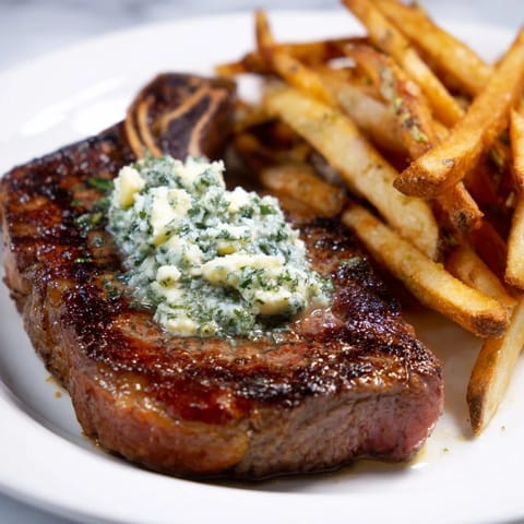 Mouthwatering image of a perfectly cooked Steakhouse Garlic Butter Steak & Fries served with golden, seasoned fries.