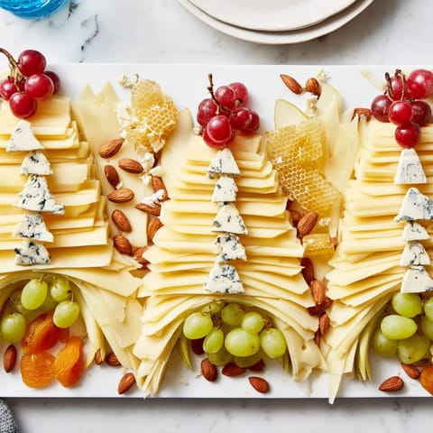 This Art Deco Arch Cheese Platter has artfully arranged cheeses with grapes and honey for serving.