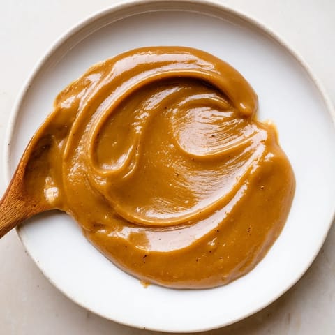 A close-up of Emirati Al Madrooba: a thick, sweet date paste swirled in a pan.