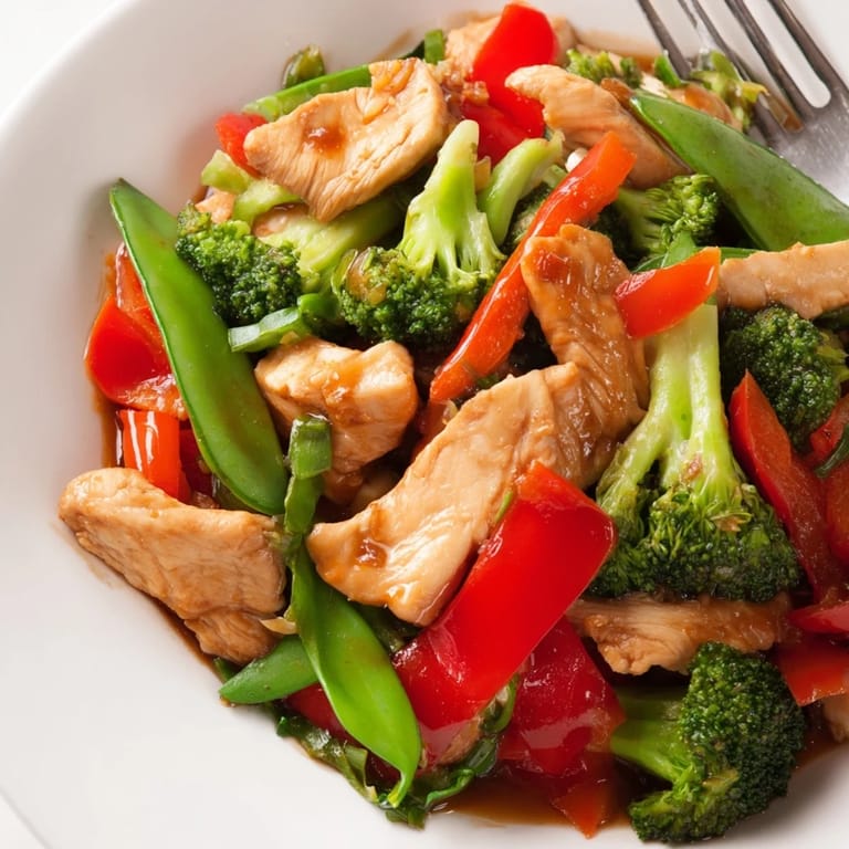 Sizzling chicken and veggie stir-fry served hot over rice, perfect for dinner.