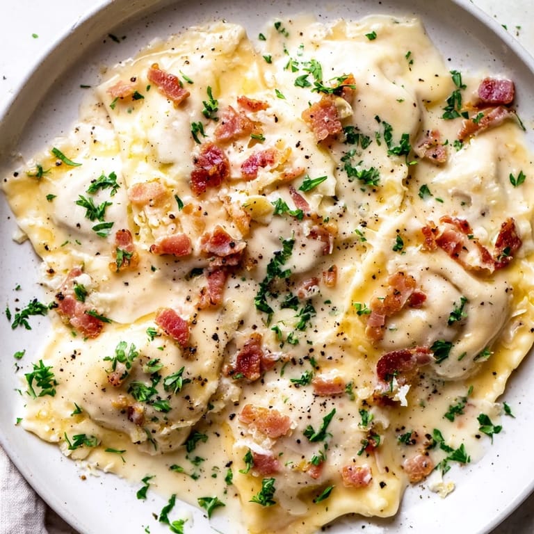 Golden, cheese-filled Olive Garden Ravioli Carbonara served with fresh parsley offers inviting savory aromas.