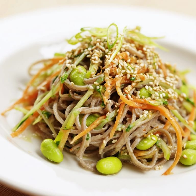 Close-up of Asian sesame noodle salad, featuring soba noodles with sesame seeds sprinkled on top.