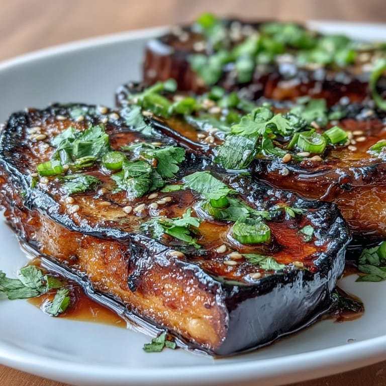 Thick, tender slices of roasted eggplant topped with a rich miso glaze, garnished with sesame seeds and fresh green onions.  